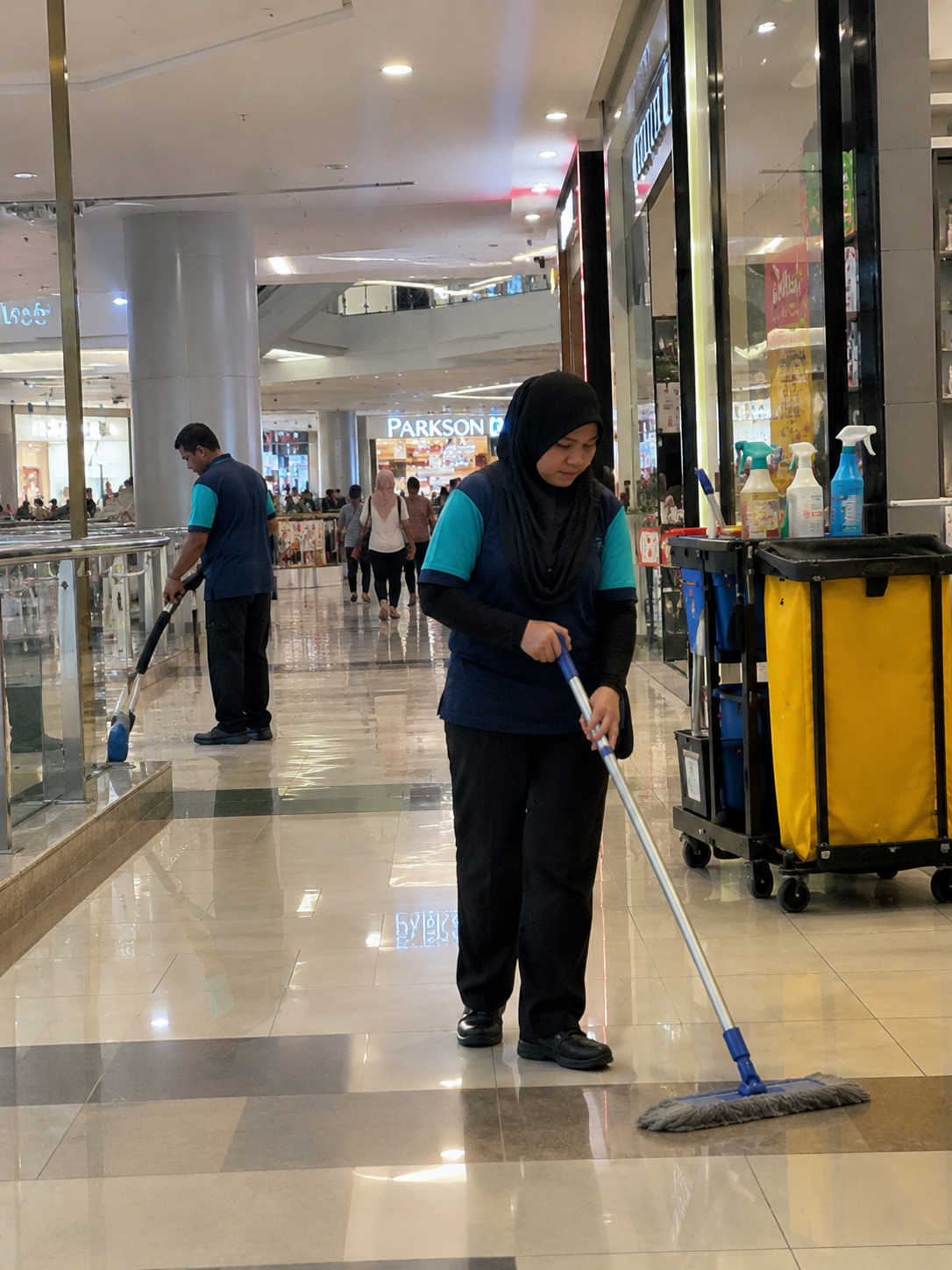 Cleaning workers mopping shopping mall floors as part of commercial and industrial cleaning services in KL