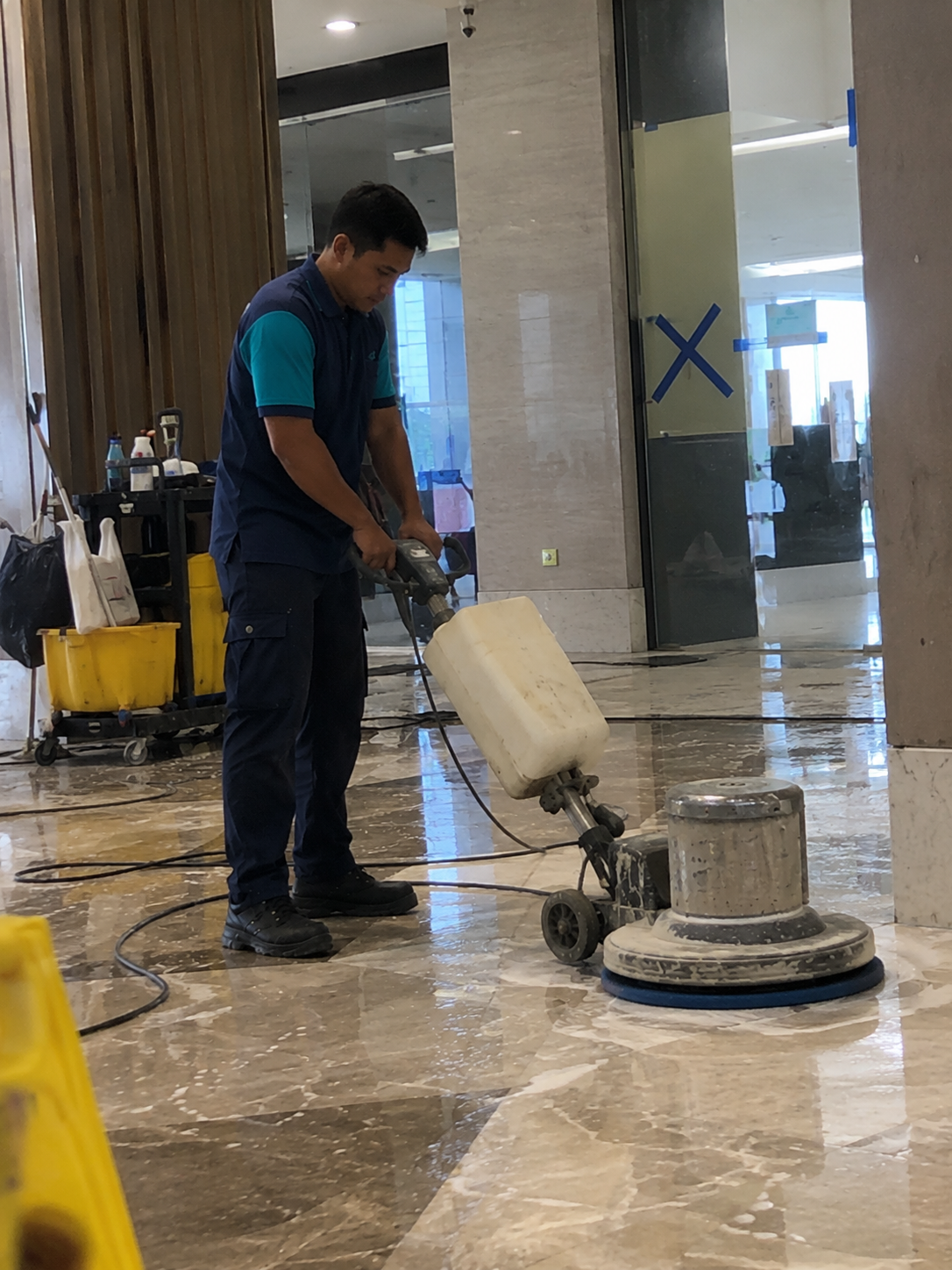 Tenaga Cekap cleaner operating a marble floor polishing machine during commercial and industrial cleaning services in KL