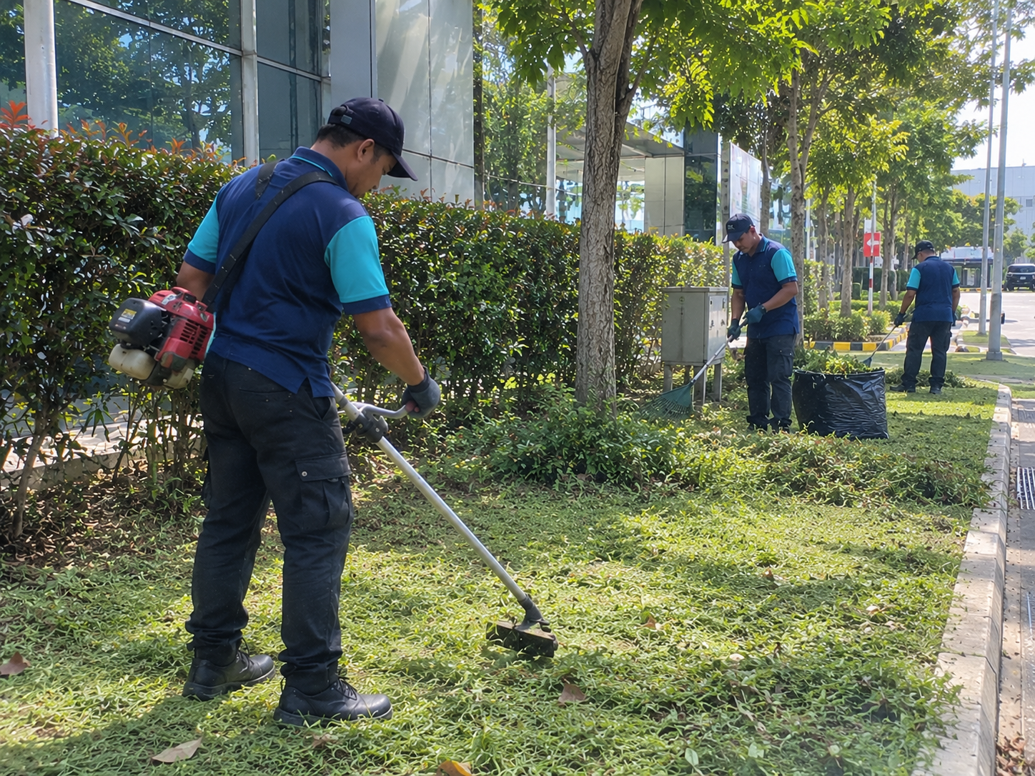 Professional workers performing outdoor grounds maintenance alongside commercial and industrial cleaning services in KL